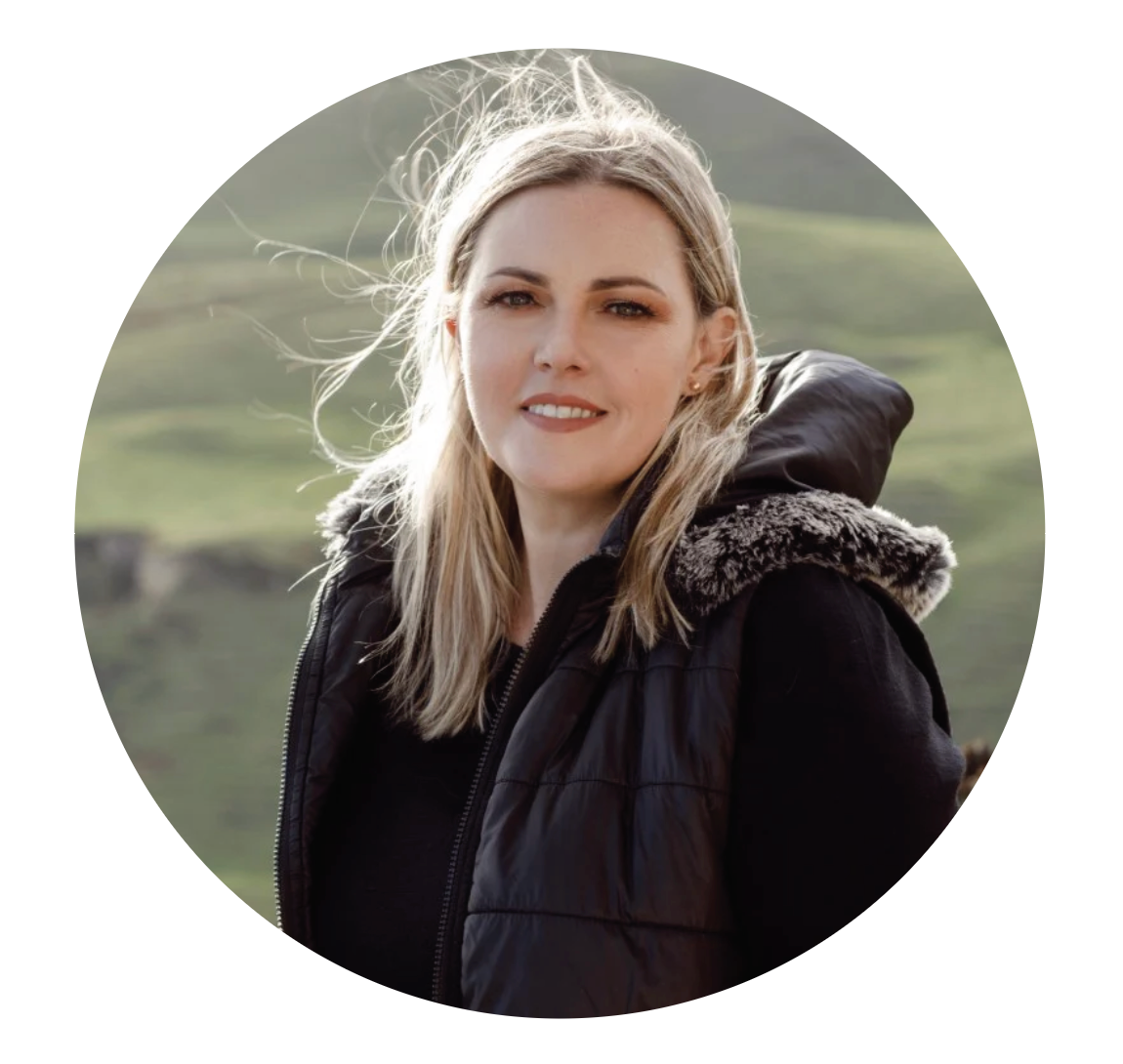 Woman wearing a 100% merino wool jumper and a black coat with faux fur-lined hood outdoors